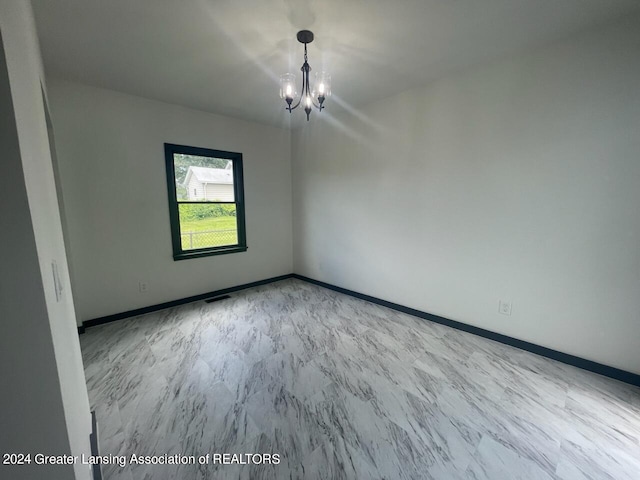 unfurnished room featuring an inviting chandelier