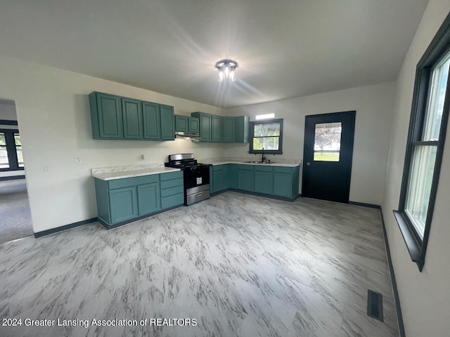 kitchen with light countertops, visible vents, gas range, under cabinet range hood, and baseboards