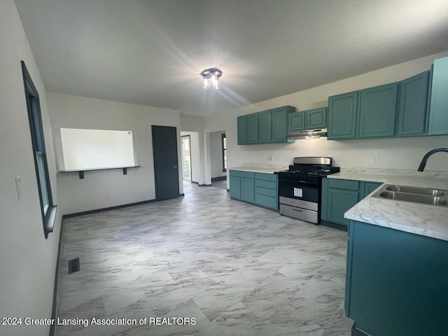 kitchen featuring gas stove, light tile patterned flooring, and sink