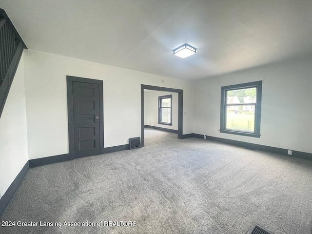 carpeted spare room featuring visible vents and baseboards