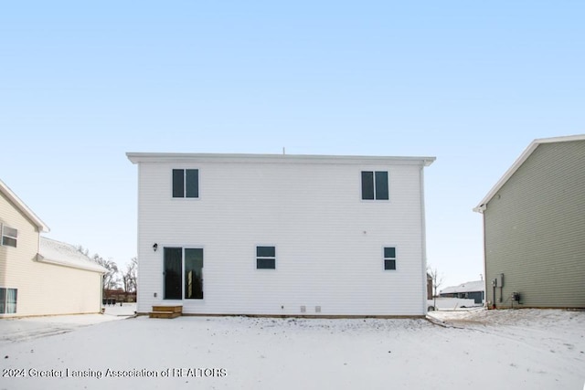 view of snow covered rear of property