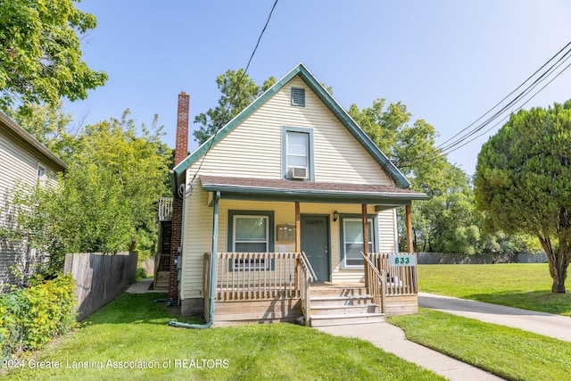 bungalow featuring cooling unit, a front yard, and a porch