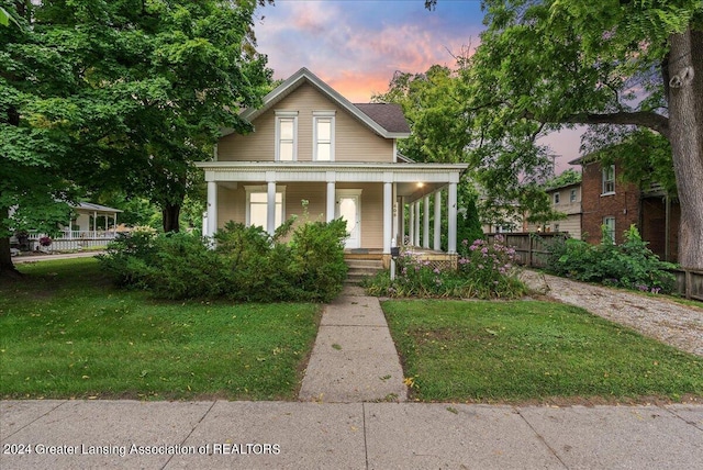 view of front of house with a porch and a yard