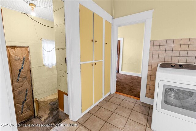 laundry room with washer / dryer, tile walls, and light tile patterned flooring