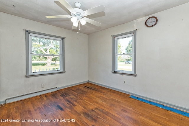 unfurnished room with plenty of natural light, dark hardwood / wood-style flooring, and a baseboard radiator