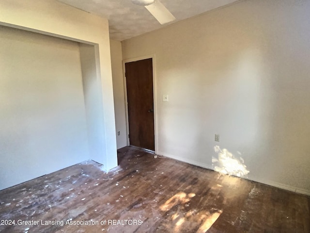 unfurnished room with ceiling fan and dark hardwood / wood-style flooring