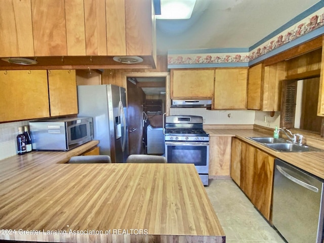 kitchen with stainless steel appliances, sink, and backsplash