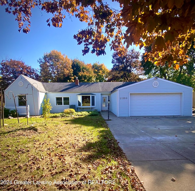 ranch-style house featuring a garage, central AC, and a front yard