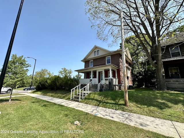 view of front facade with a front lawn and covered porch