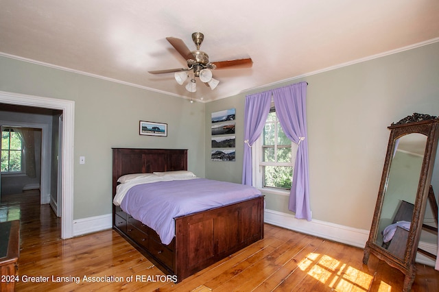 bedroom featuring light hardwood / wood-style flooring, ceiling fan, and ornamental molding