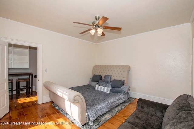 bedroom featuring ceiling fan, hardwood / wood-style flooring, and ornamental molding