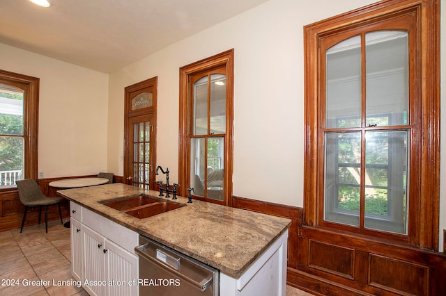 kitchen featuring dishwasher, light stone counters, sink, and white cabinetry