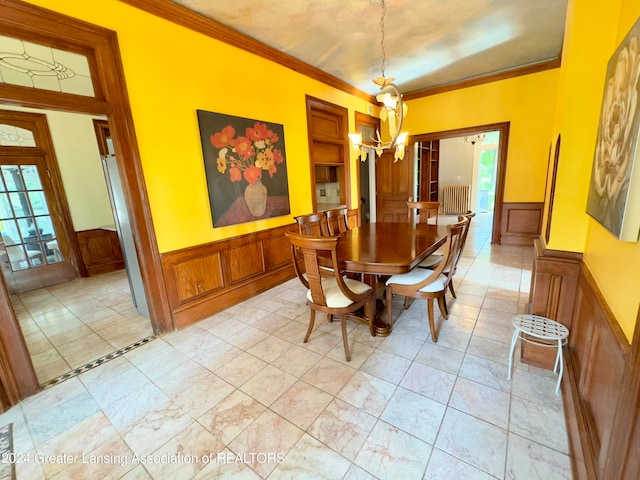 dining room with ornamental molding, radiator heating unit, and an inviting chandelier