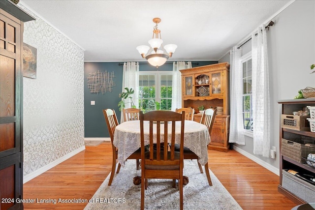 dining area featuring a textured ceiling, plenty of natural light, light hardwood / wood-style floors, and a chandelier