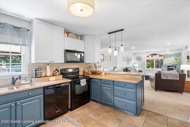 kitchen with a healthy amount of sunlight, black appliances, white cabinetry, and sink