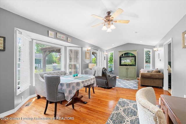 living room featuring ceiling fan, light hardwood / wood-style flooring, lofted ceiling, and a healthy amount of sunlight