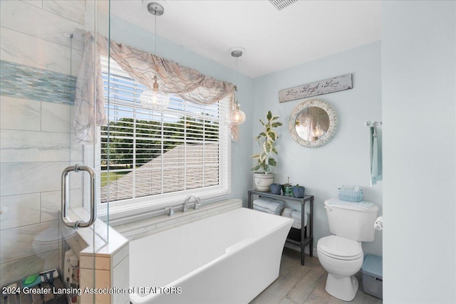 bathroom featuring plus walk in shower, wood-type flooring, and toilet