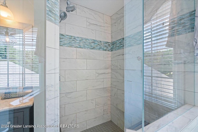 bathroom with vanity and a tile shower