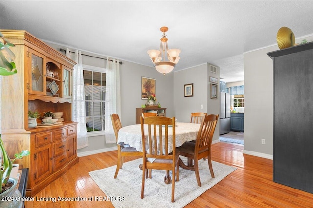 dining area featuring an inviting chandelier and light wood-type flooring