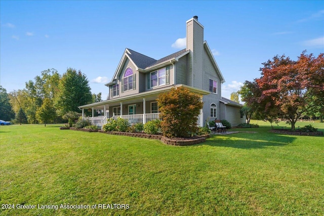 view of side of property with covered porch and a yard