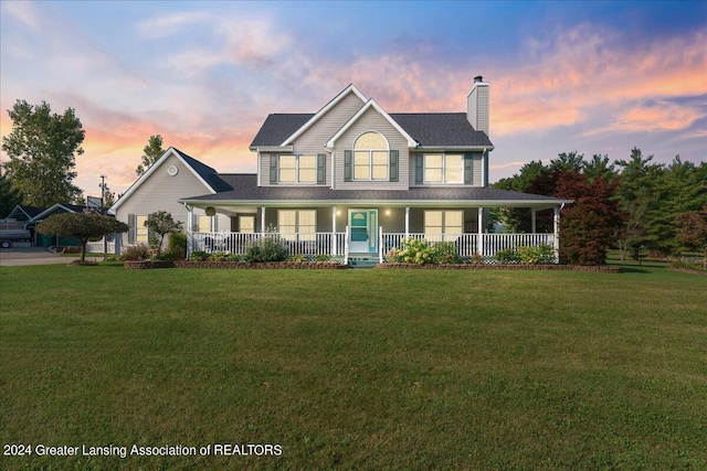 farmhouse-style home featuring a porch and a lawn