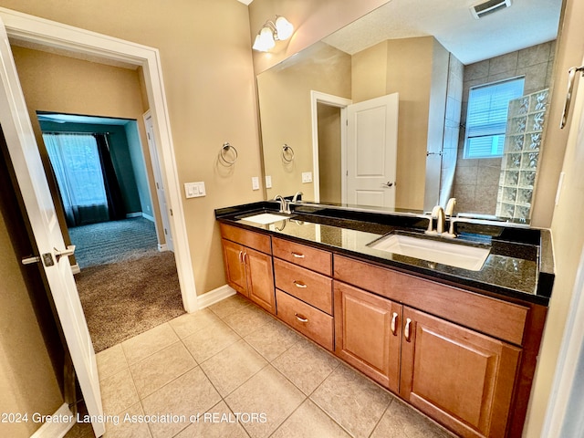 bathroom featuring vanity, a shower, and tile patterned flooring