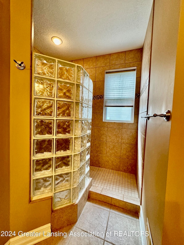 bathroom with tiled shower, tile patterned floors, and a textured ceiling