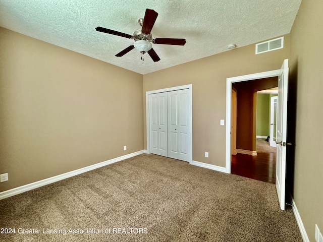 unfurnished bedroom with a closet, a textured ceiling, ceiling fan, and carpet floors