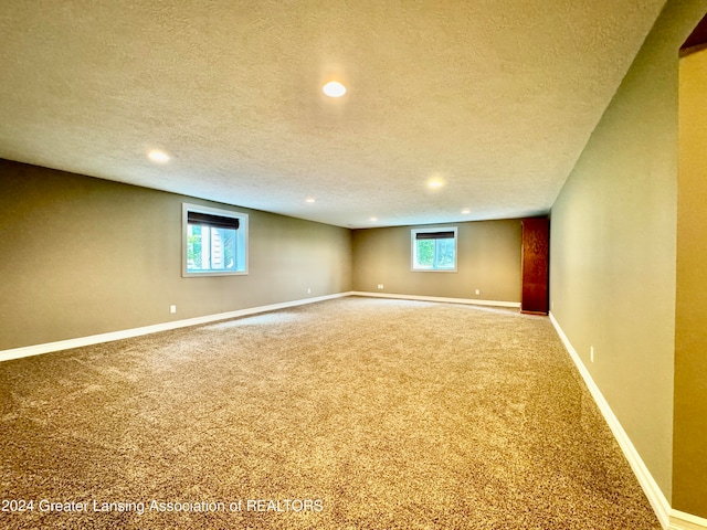 carpeted empty room with a textured ceiling