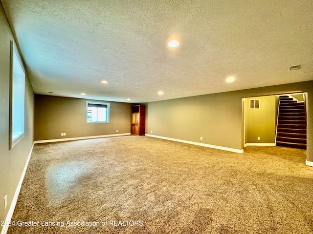 empty room with a textured ceiling and carpet floors