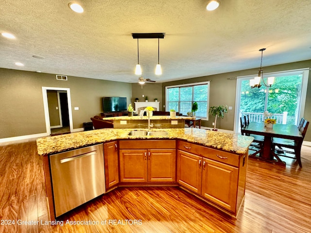 kitchen featuring light hardwood / wood-style flooring, stainless steel dishwasher, and a center island with sink