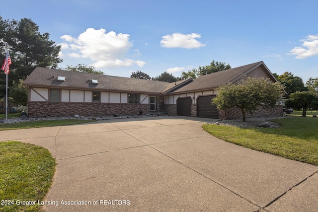 ranch-style home with a garage and a front lawn