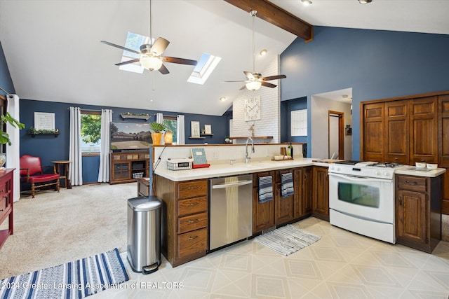 kitchen with a skylight, ceiling fan, white range, high vaulted ceiling, and stainless steel dishwasher