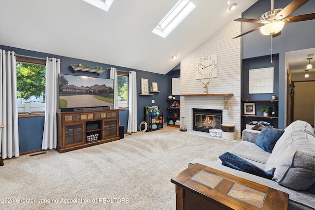 living room with a wealth of natural light, a fireplace, high vaulted ceiling, and a skylight