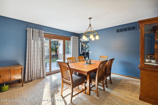 carpeted dining space featuring a textured ceiling and a notable chandelier