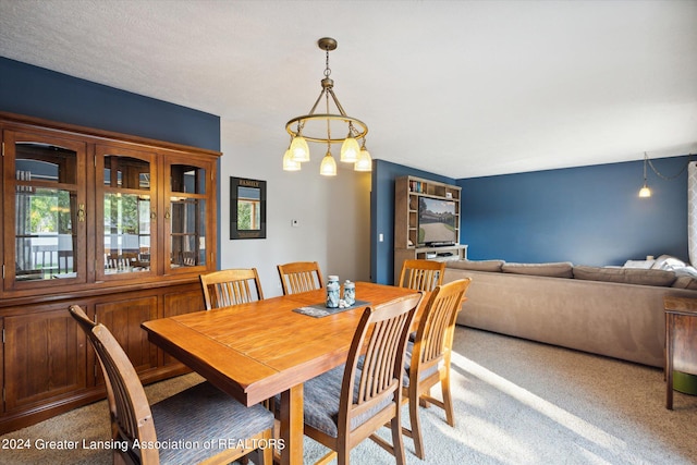 dining area with light colored carpet and an inviting chandelier