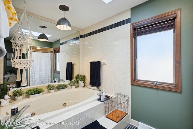 bathroom featuring a wealth of natural light and tiled tub