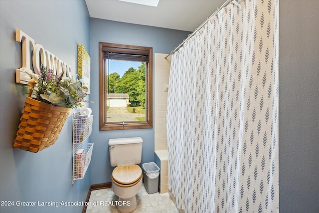 bathroom featuring a skylight, toilet, and tile patterned floors