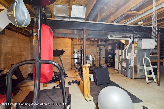 exercise area with gas water heater, concrete flooring, and heating unit