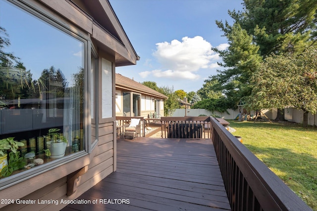 wooden deck featuring a lawn and a playground