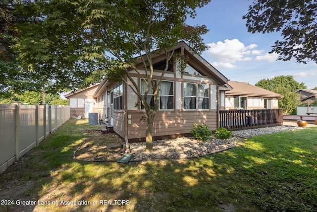 back of house with a yard, central AC unit, and a wooden deck