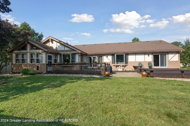 back of house featuring a wooden deck and a lawn