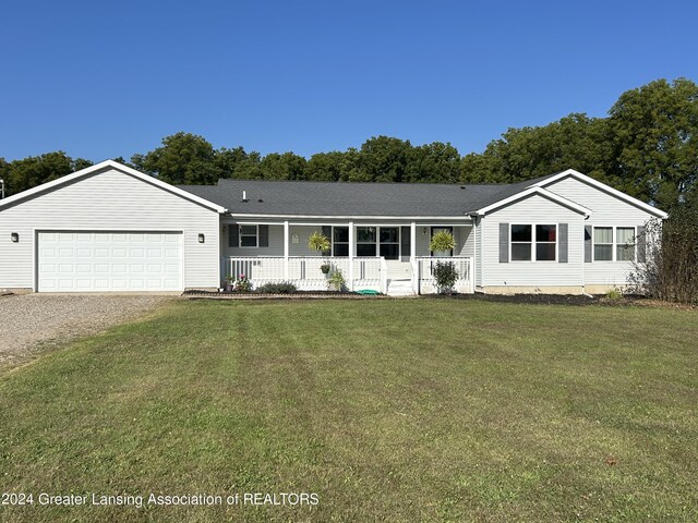 single story home featuring a front yard, a porch, and a garage