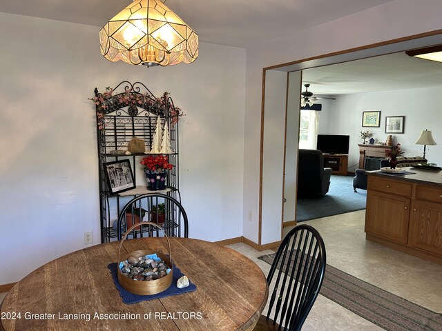 dining area with ceiling fan with notable chandelier