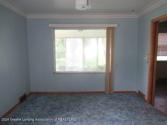 carpeted empty room featuring ornamental molding