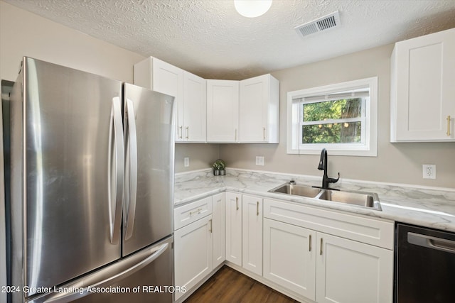 kitchen with white cabinetry, stainless steel refrigerator, sink, light stone counters, and dishwasher