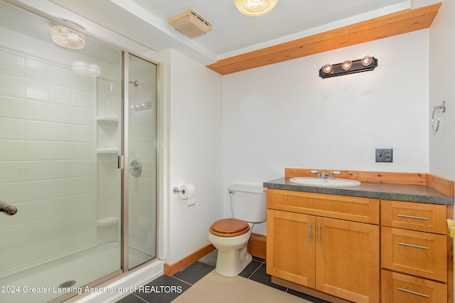 bathroom with tile patterned floors, walk in shower, vanity, and toilet