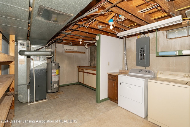 basement with heating unit, gas water heater, electric panel, and washing machine and clothes dryer