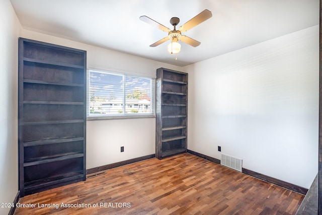 unfurnished room with dark hardwood / wood-style flooring and ceiling fan