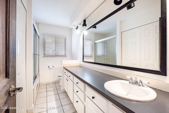 full bathroom with tile patterned floors, vanity, toilet, and enclosed tub / shower combo